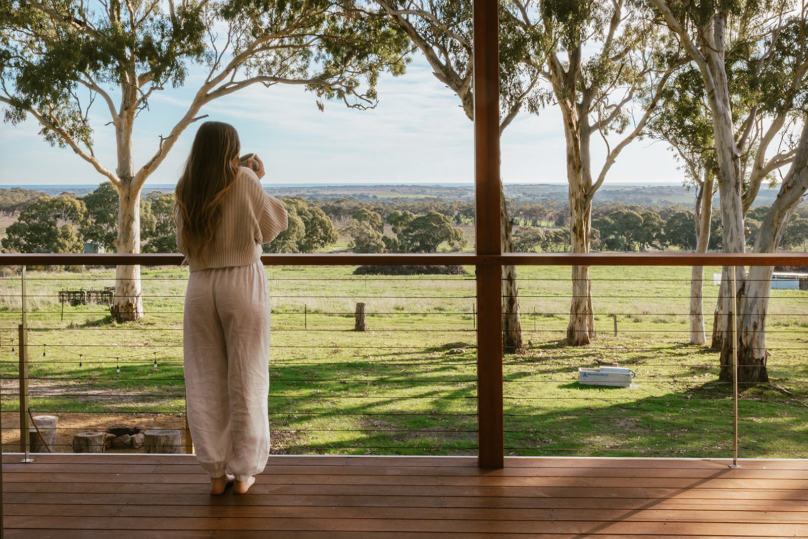 A guest on the villa deck looking out across the farm and the plain beyond