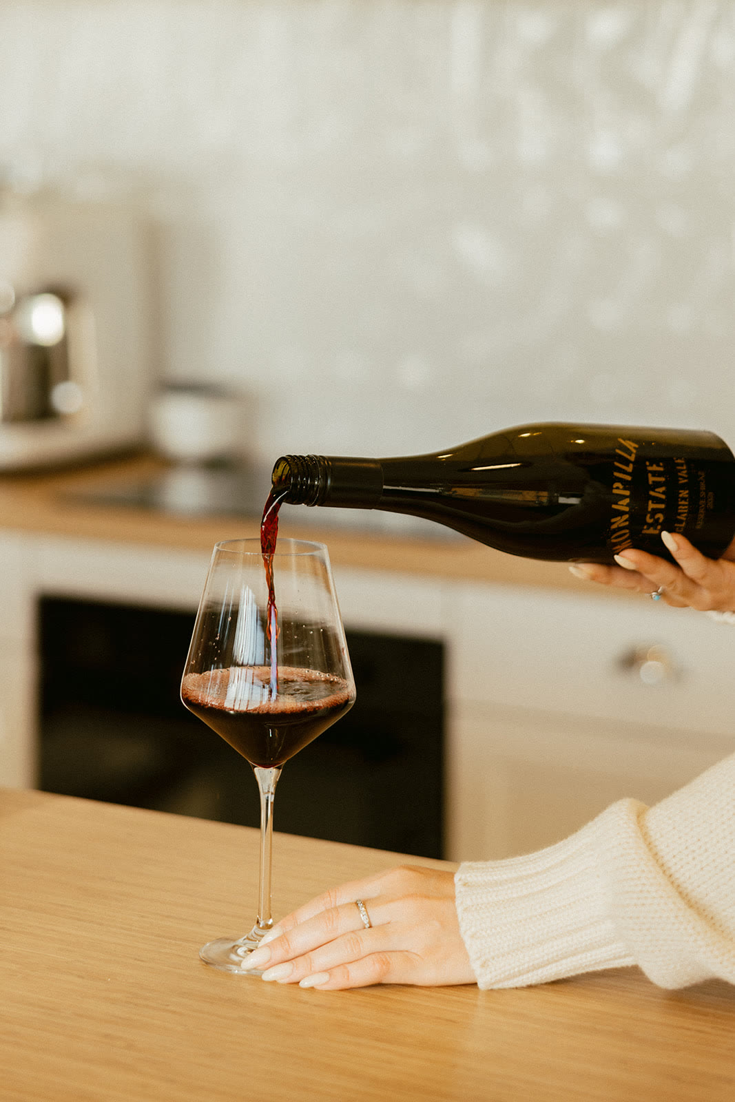 A bottle of Monapilla Shiraz being poured into a glass on the kitchen bench